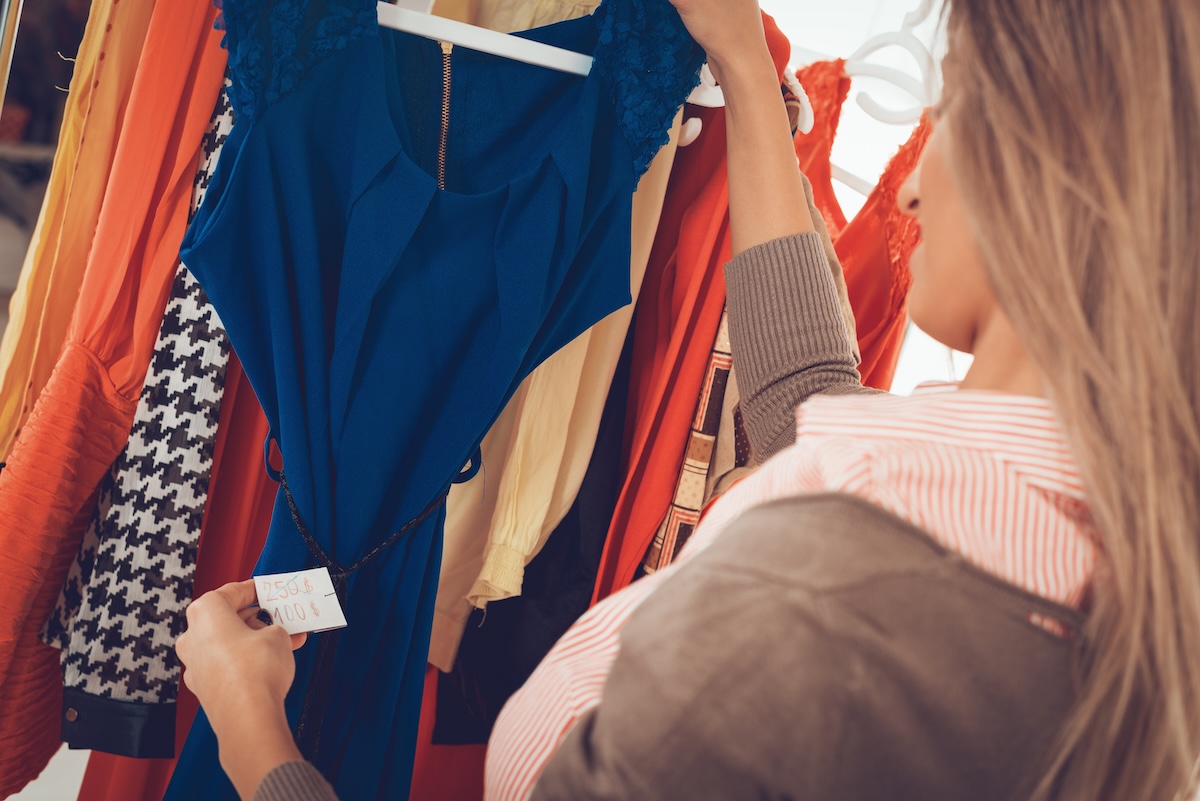 Dame schaut in einem Kleidungsgeschäft auf ein Preisschild