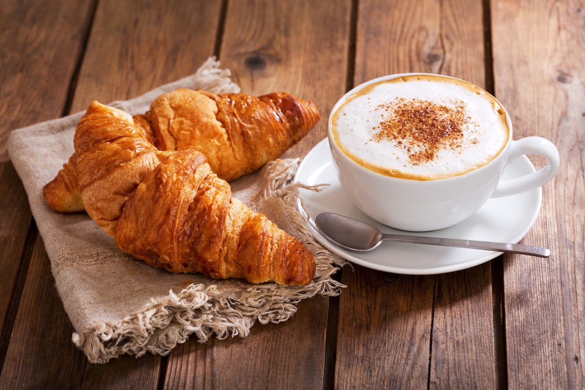 Frühstücken mit Croissant und Kaffee